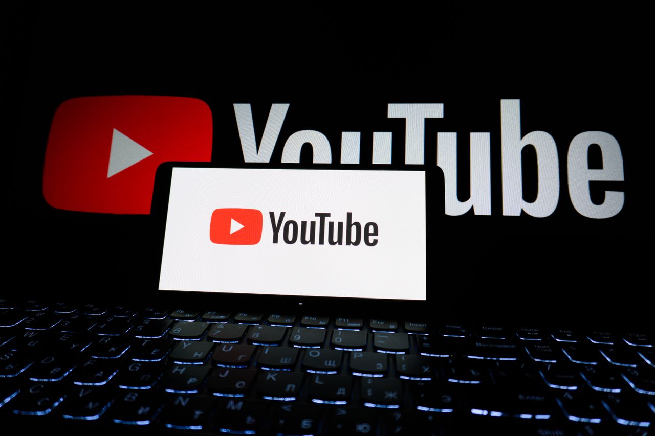 Close-up view of the YouTube logo shown on a laptop screen in a dark setting.